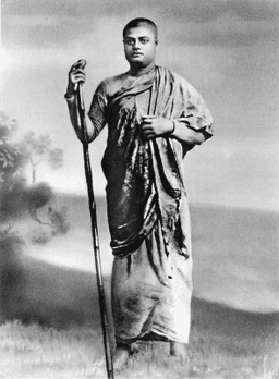 Vivekananda standing with walking stick, similar to V17, but more faced forward.