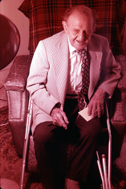 unknown man seated with crutches