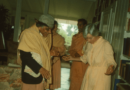 Swami Aseshananda laughing with Sister Prabhaprana in a waist shot with Swami Aparananda and a nun behind them